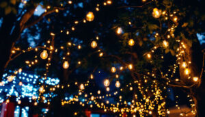 A photograph of a beautifully illuminated outdoor space featuring string lights draped elegantly across trees or a patio